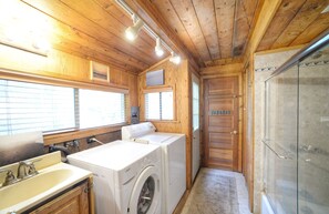 Downstairs bathroom with washer and dryer, shower and tub.