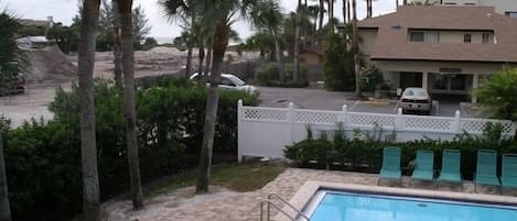 Units directly overlook one of the pools (the beach is just beyond the palm trees