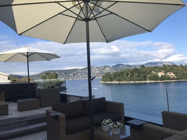 Large Jacuzzi and comfortable furniture under shady beach umbrellas