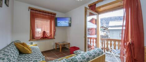 Living area with wall-mounted TV, with 2 single sofa beds