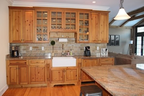 Cooks' kitchen with high-end appliances, granite countertops and farmhouse sink.