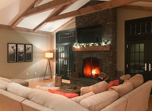 Warm, inviting great room with rustic beams, vaulted ceiling and large sectional