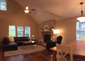 Great room features leather furniture and ceiling fan
