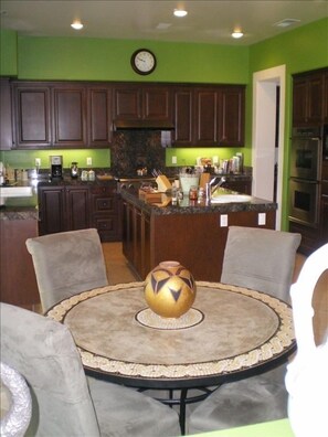 The bright eat-in kitchen is well-stocked and features stainless  appliances.