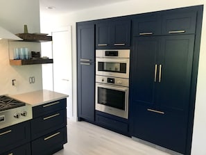 Chef's kitchen with built in fridge and wall ovens
