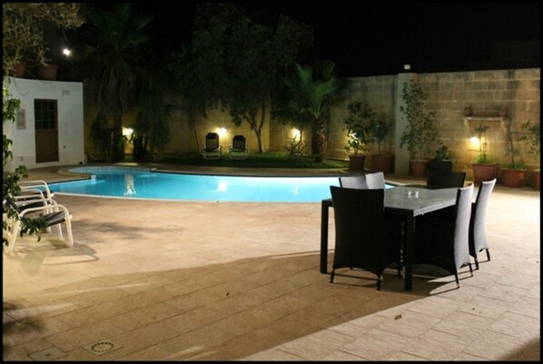 Pool area with large dining area, sunbeds, BBQ and massive outdoor space.