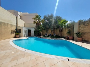 Pool area with large dining area, sunbeds, BBQ and massive outdoor space.