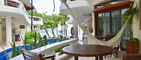 Ocean view balcony with chairs and hammock.