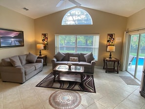 Great Room with new couches and sliding door out to pool deck