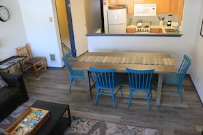 Dining area with bench (seats 3)  and 4 chairs, kitchen adjacent.