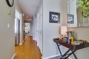 View of hallway with kitchen on the left, bedroom door in front and entrance to condo on the right