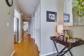 View of hallway with kitchen on the left, bedroom door in front and entrance to condo on the right