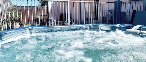 Huge hot tub between the rear courtyard and lawn area. 