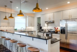 Bar looking into kitchen with 5 stools.