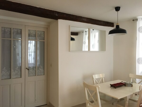 Curtained french door entrance to bedroom with privacy, next to dinning area.