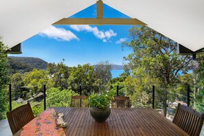 Dining on the deck or relax on cane easy chairs ...