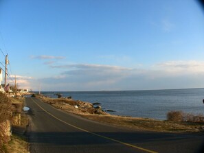 A few steps down the road in front to the beach! Driveway to cottage on left.
