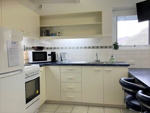 Well equipped kitchen with stove, microwave, kettle, coffee machine