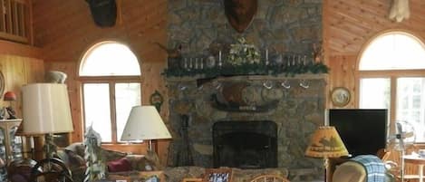 This room boasts 2.5 stories, with exposed beam ceilings with fans and a loft overhead. The floor-to-ceiling stone fireplace is the room’s magnificent focal point. The room also includes a new 47” HD television, dining area with seating for up to 10 guests, and a bar with small refrigerator. 