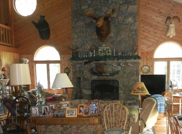 This room boasts 2.5 stories, with exposed beam ceilings with fans and a loft overhead. The floor-to-ceiling stone fireplace is the room’s magnificent focal point. The room also includes a new 47” HD television, dining area with seating for up to 10 guests, and a bar with small refrigerator. 