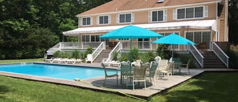 Back yard with heated pool, awing on upper deck, 
lounge chairs with cushions