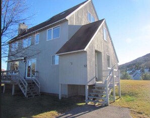 Outside of house. Wrap around deck with plenty of firewood. There is an electric fold away awning.