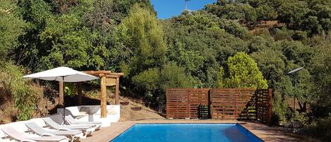 The pool gets sun all day, accessed by steps down from the house