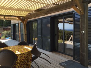 Terrasse et table de repas. Notez le reflet de la vue Mer..toujours omniprésente