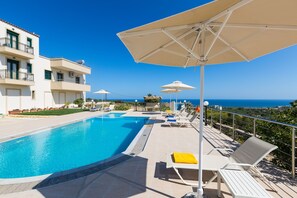 The pool area is equipped with sun beds and umbrellas.