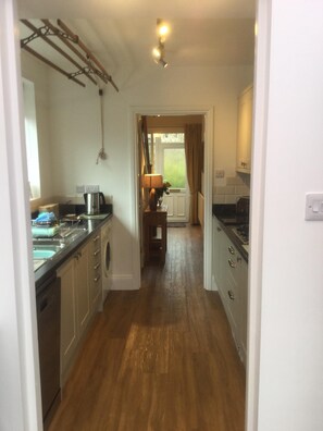 Well equipped kitchen leading to hallway