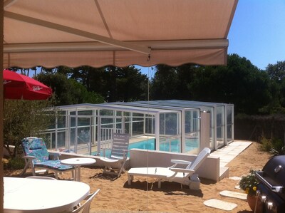 Maison individuelle avec piscine privée et couverte, jardin de sable clos.