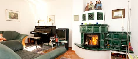 Wohnzimmer mit Klavier und Kamin