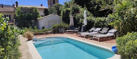 Piscine avec coin transats et parasols