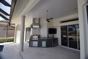 Outdoor kitchen with Napoleon grill, mini sink, and mini fridge. 