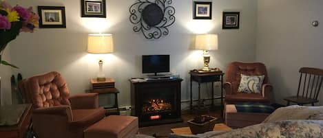 Comfortable parlor with fireplace and cable TV.