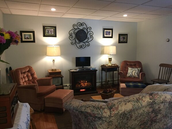 Comfortable parlor with fireplace and cable TV.