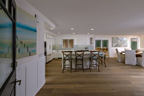 View of kitchen from entry and 8-person round dining table.