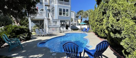 The backyard is beautifully landscaped with seating for 12 at the pool.