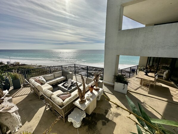 Main balcony overlooking beach, uncovered seating area and covered dining area