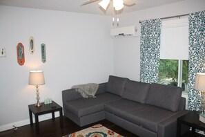 View of living area upon entry. Pull out sofa bed under couch