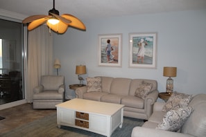 Living area with sofa, love seat and swivel chair.
