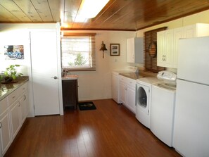 Large utility room with washer, 2 dryers, and extra refrigerator.