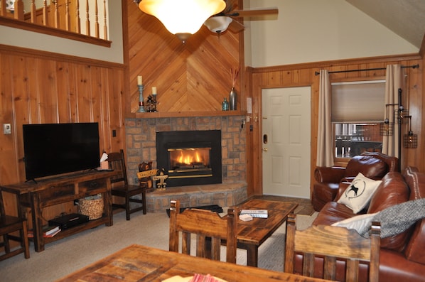 Living area with gas fireplace and 50 inch TV.