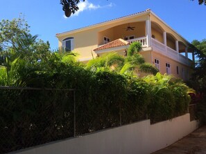 Side of house with wrap around porch on upper level.
