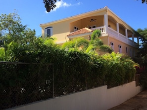 Side of house with wrap around porch on upper level.