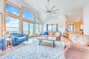 An open, airy great room with a wall of windows showcasing first-class oceanfront view