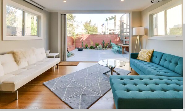 Downstairs media-family room with patio door/wall fully open to garden