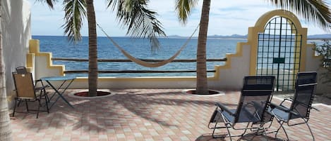 Beachfront patio is sheltered from wind: spread out your gear to dry, and relax!