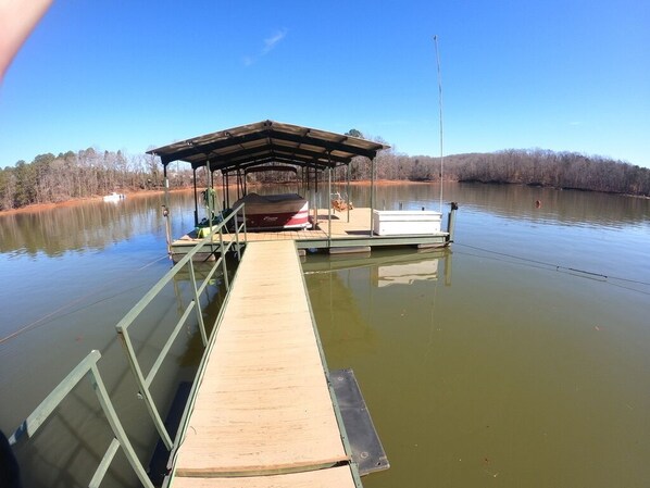 Dock with sun bathing area and swing!  +16 feet deep and plenty of boat parking!