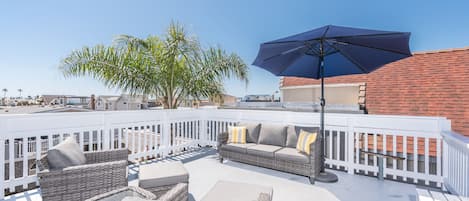 Exclusive rooftop deck with panoramic views includes ample seating.